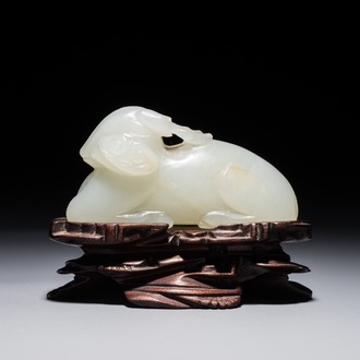 A Chinese jade carving of a ram on wooden base, 19th C.